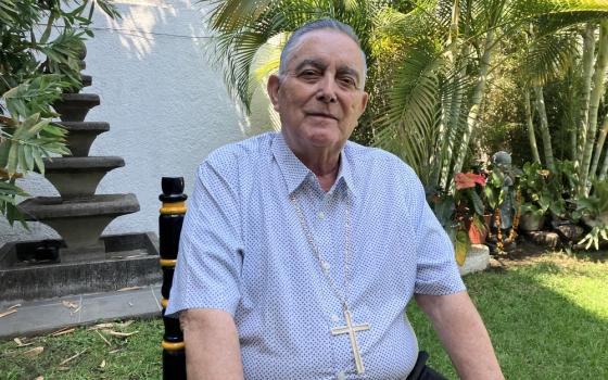 Casual portrait of bishop sitting in garden. 